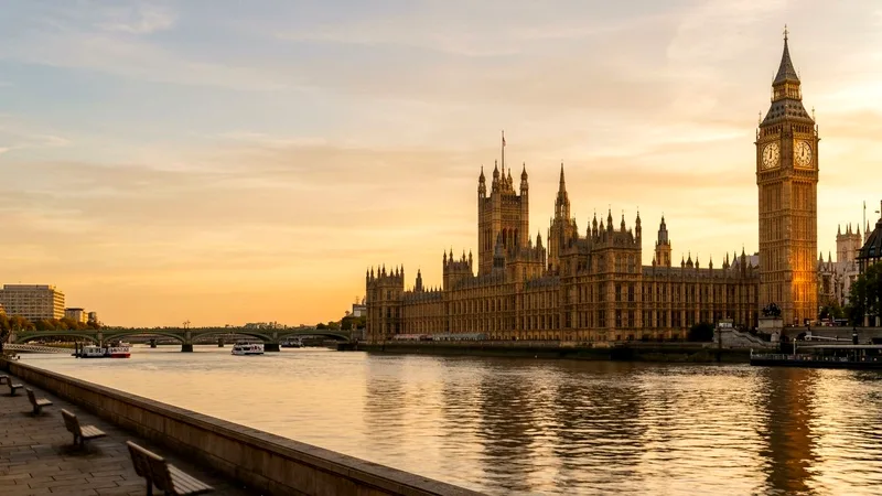 Houses of Parliament and Elizabeth Tower beside the River Thames at golden hour.